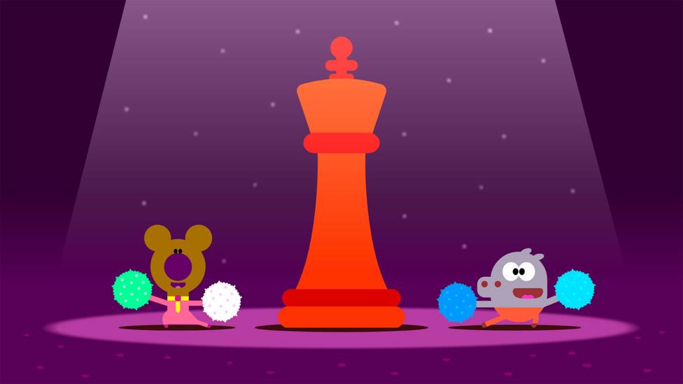 Two Hey Duggee squirrels pose after cheering with pompoms by a red king chess piece.