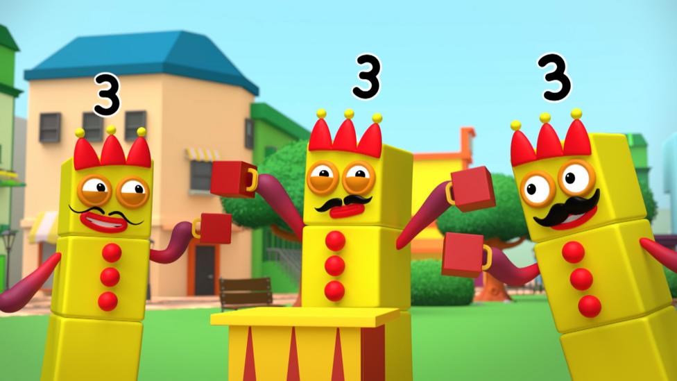 Three Numberblock Threes holding cups, wearing crowns and moustaches, cheersing each other and looking excited.