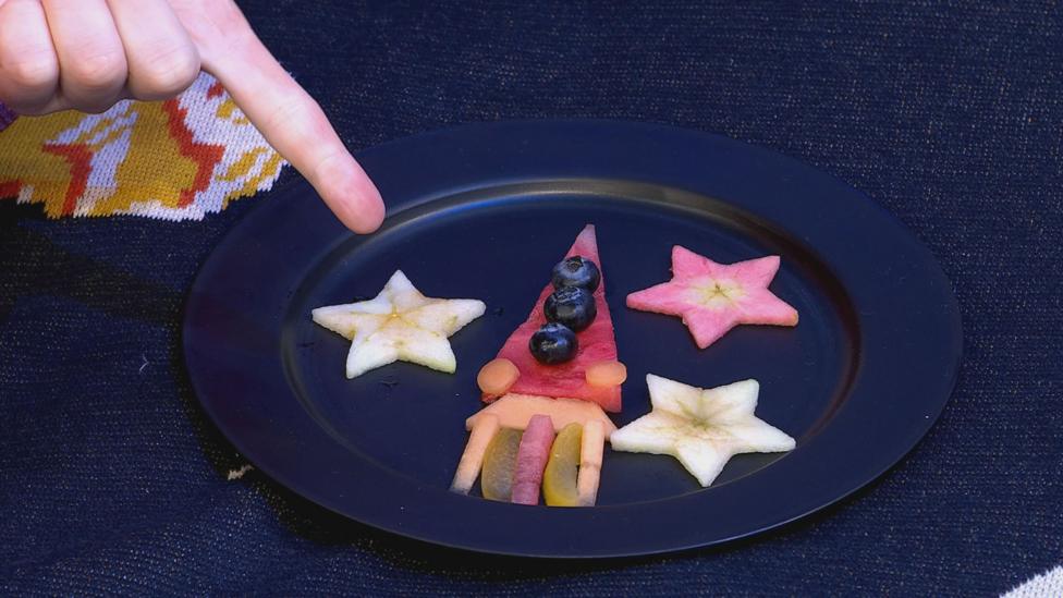 Dark plate featuring a rocket made out of melon shapes.