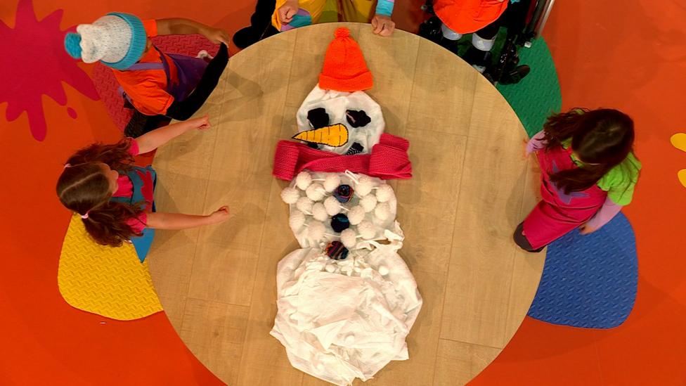 A snowman made from white bundled cloth on a table.