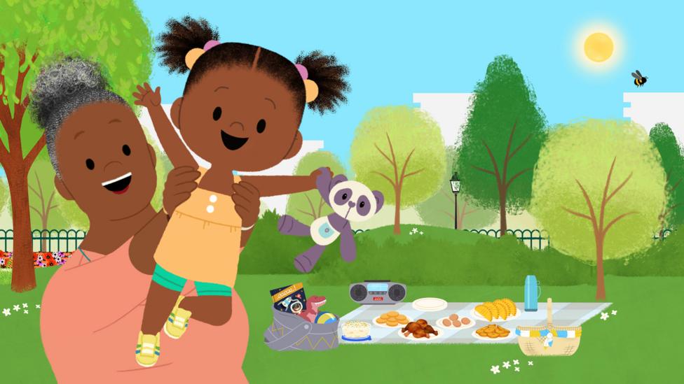 JoJo smiling as she's being lifted up by Gran Gran in a park, with picnic items and green foliage visible behind