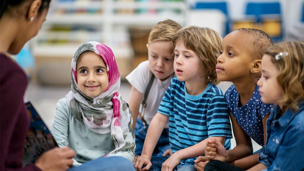 Children listening to a teacher reading a story