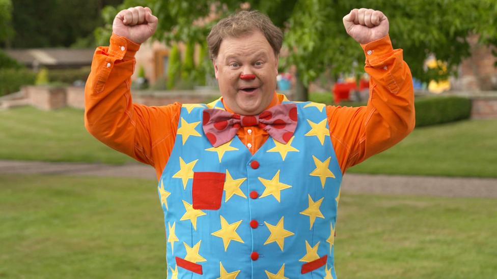 Mr Tumble, the star of Something Special, cheering in a park