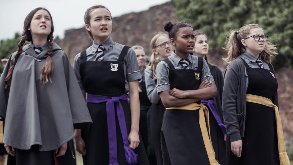 Characters from The Worst Witch look to the sky