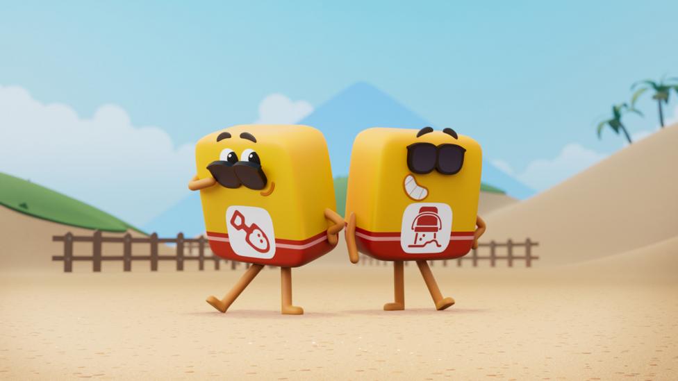 Two yellow-and-red Do Blocks standing on a beach in Wonderblocks