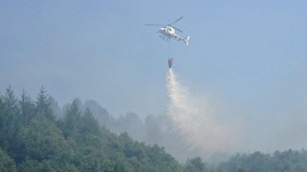 A helicopter dropping water on the blaze near Bryn Pica landfill site in Aberdare