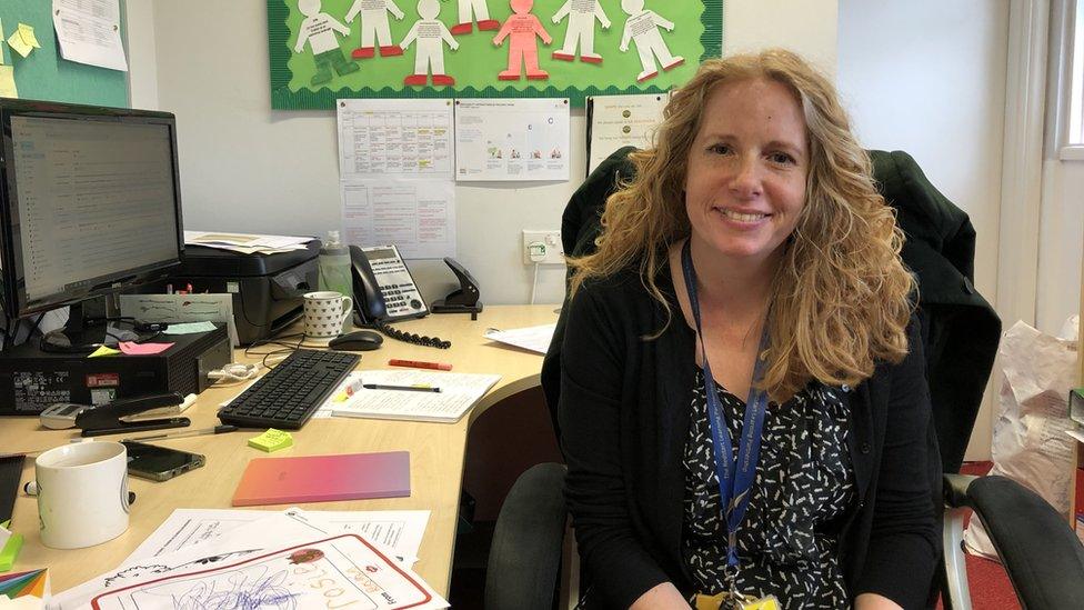 A woman with curly hair sitting at a desk