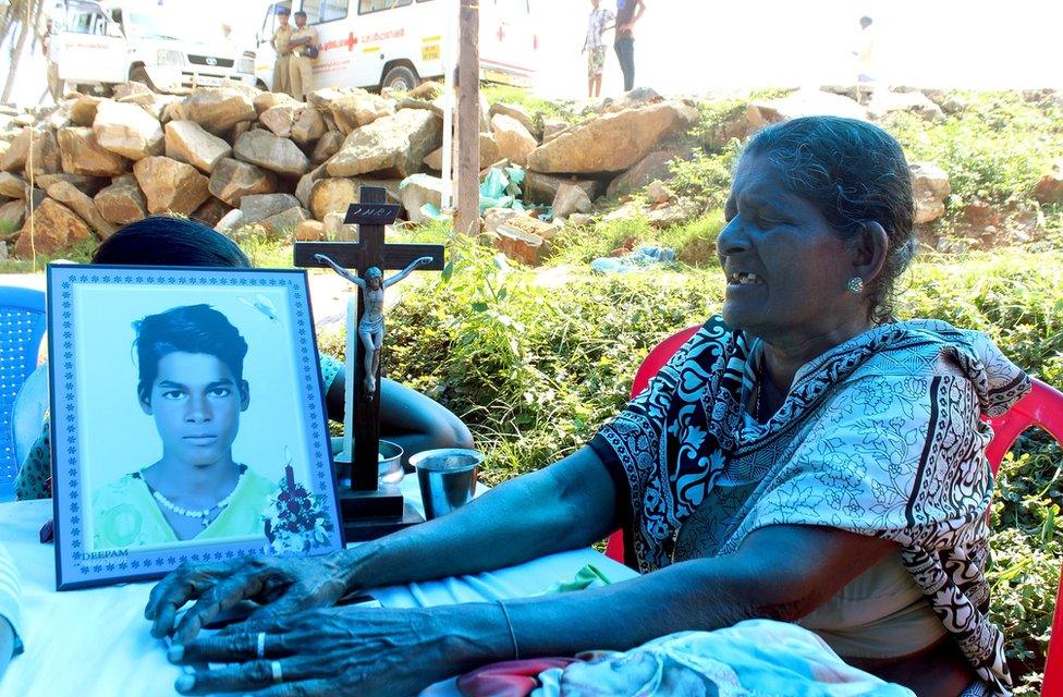 Susie Vincent is crying next to a photograph of her 15-year-old grandson, Vineesh.