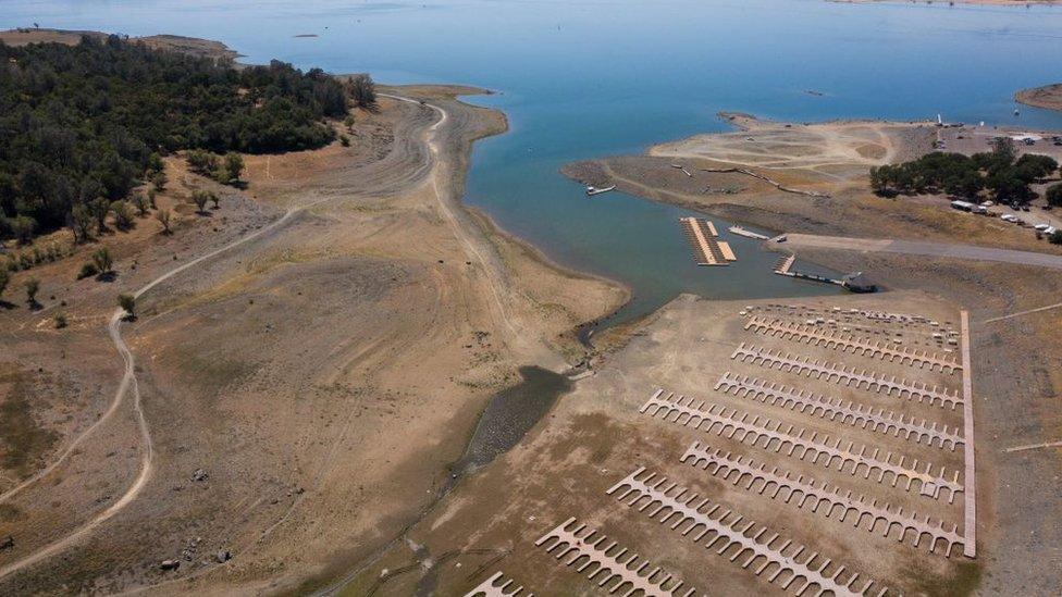 Empty boat slips sit on a dry lake bed at California's Folsom Lake Marina