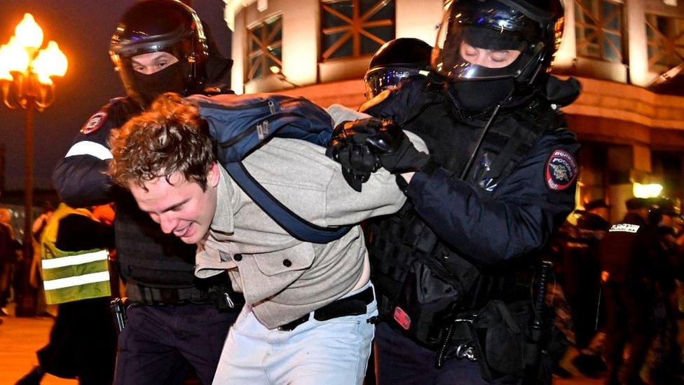 Man being detained by police officers