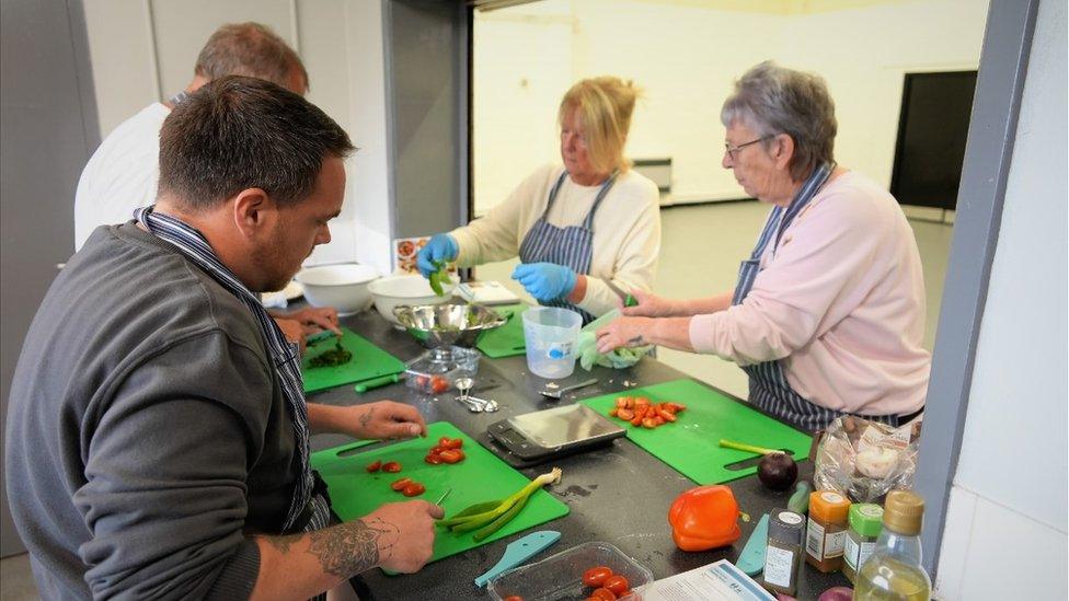 People being taught to cook healthy