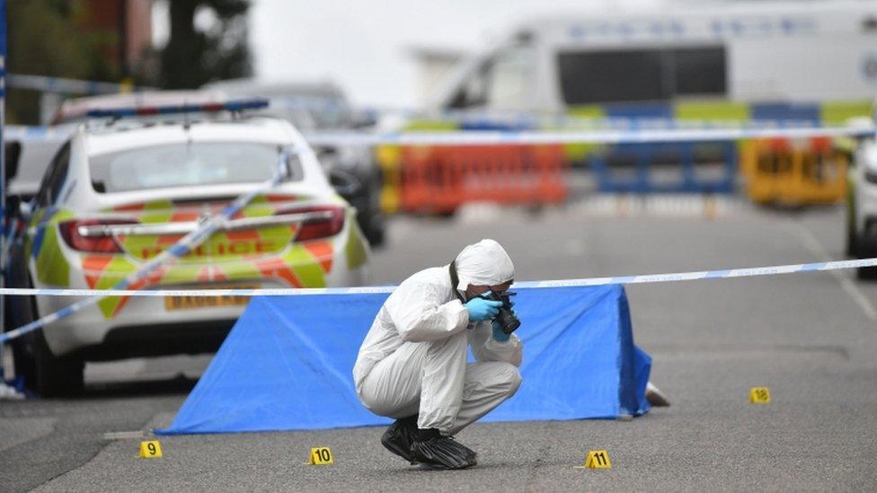 A police forensics officer taking photographs in Irving Street