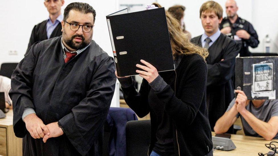 Lina E (centre, covering her face), her lawyers Erkan Zünbül (second left) and another defendant (right) are seen in the courtroom at the higher regional court in Dresden, eastern Germany, on 31 May 2023