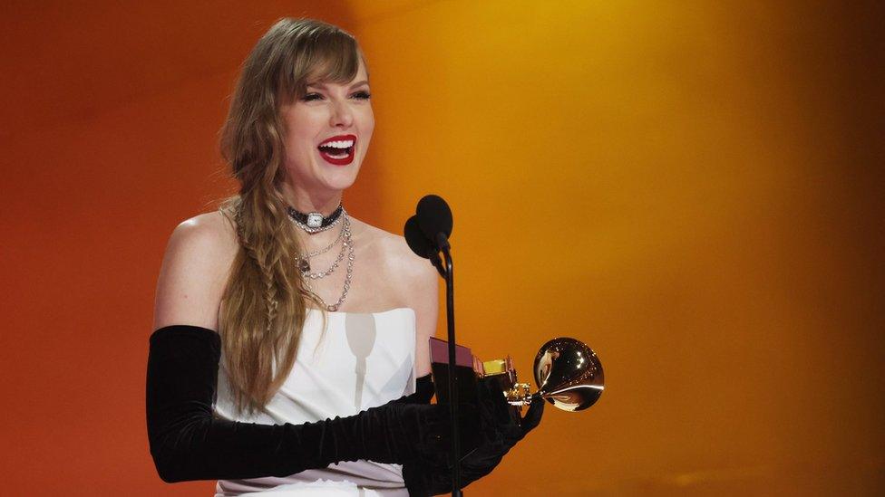 taylor swift smiling after receiving a grammy award