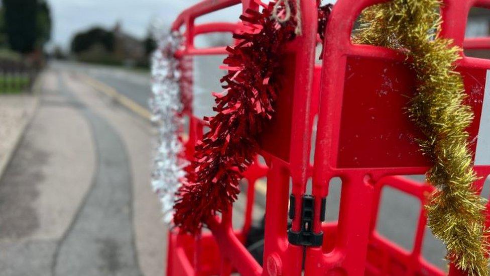 Roadwork barrier draped in tinsel