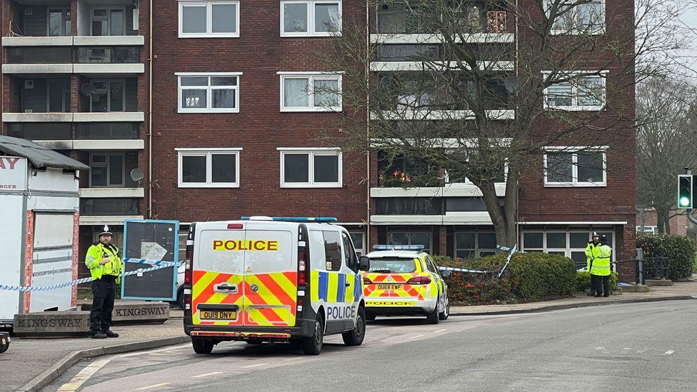 Three police officers and two police vehicles outside Carlton Way, Cambridge