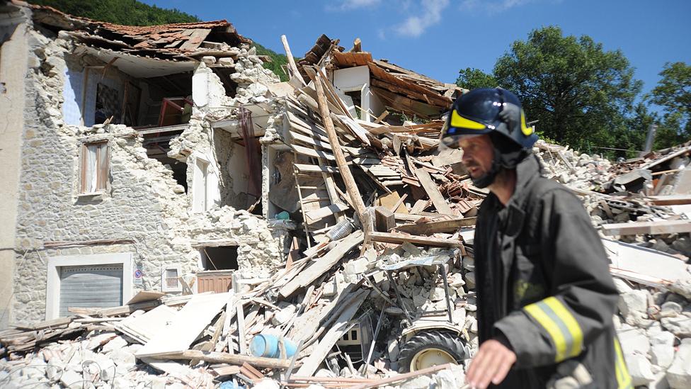 A firefighter next to collapsed building in Pescara del Tronto, 25 Aug 16