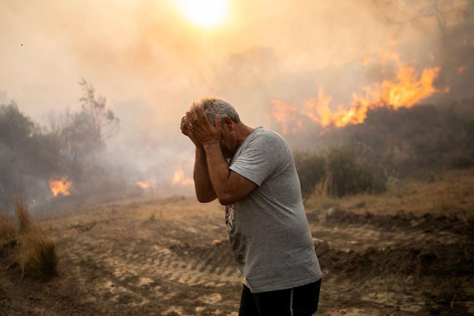 A man reacts as a fire burns into the village of Gennadi on the Greek Aegean island of Rhodes, on July 25, 2023.