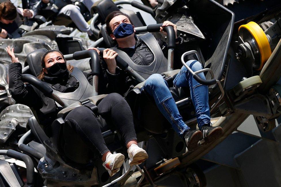 People ride the Swarm rollercoaster