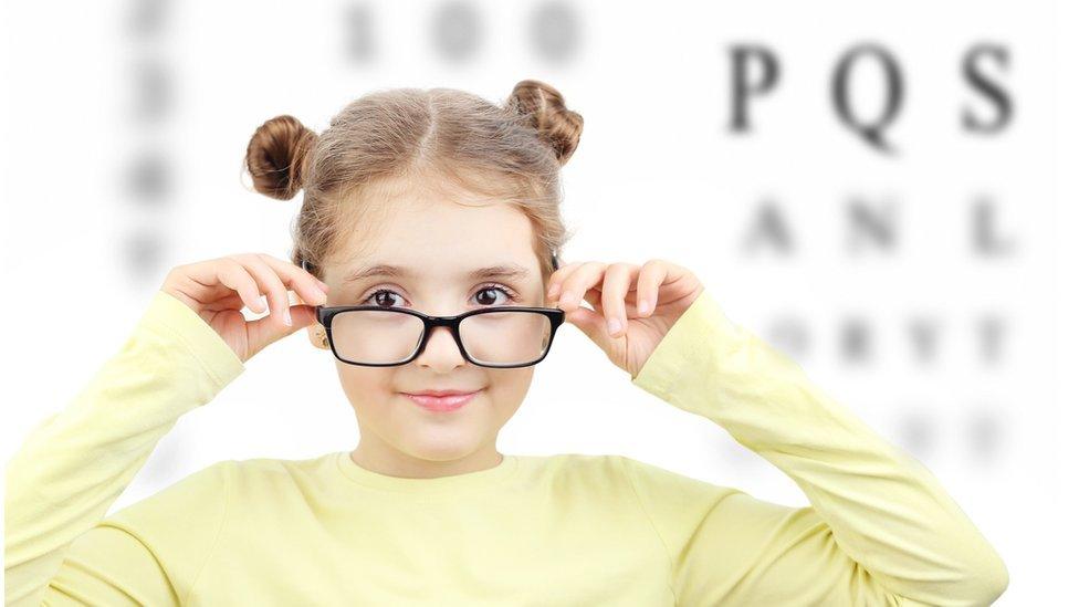 Girl with glasses in front of letters