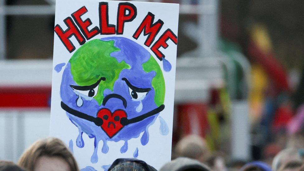 People carry a sign as they attend a protest during the UN Climate Change Conference COP26 in Glasgow.