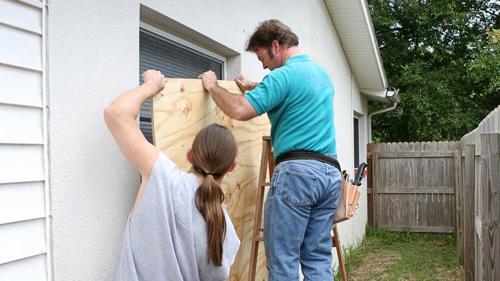 people boarding up windows