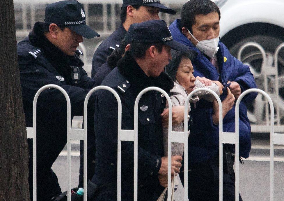 Police officers take away a supporter of rights lawyer Pu Zhiqiang near the Beijing Second Intermediate People"s Court during his trial in Beijing, Monday, 14 December 2015