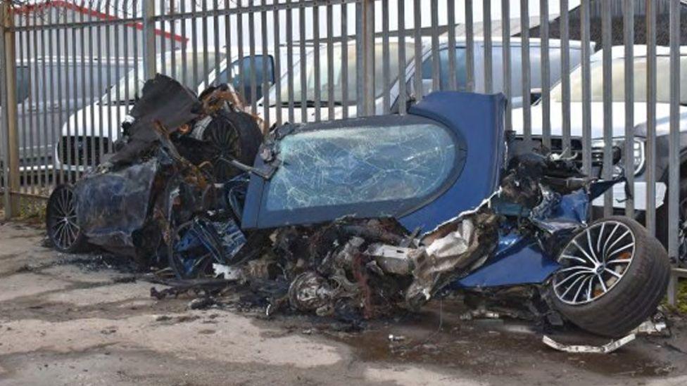The remains of a crushed and mangled blue supercar