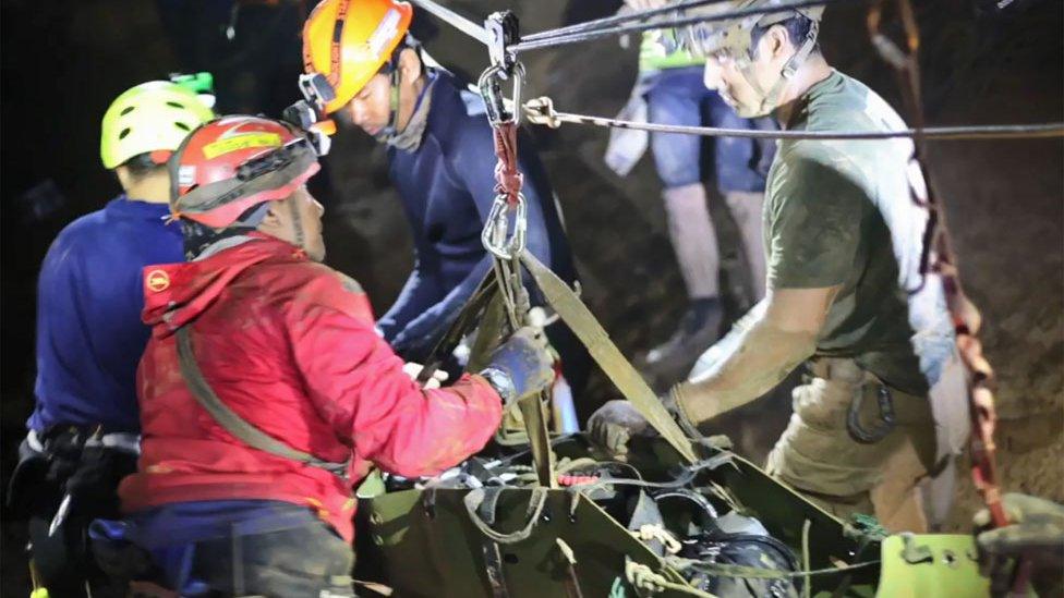 Boy being moved by rescuers inside the cave