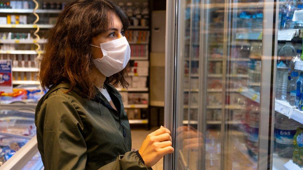 Woman looks into shop shelf