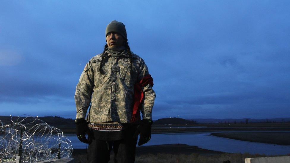 Man gazing at bared wire near Standing Rock.