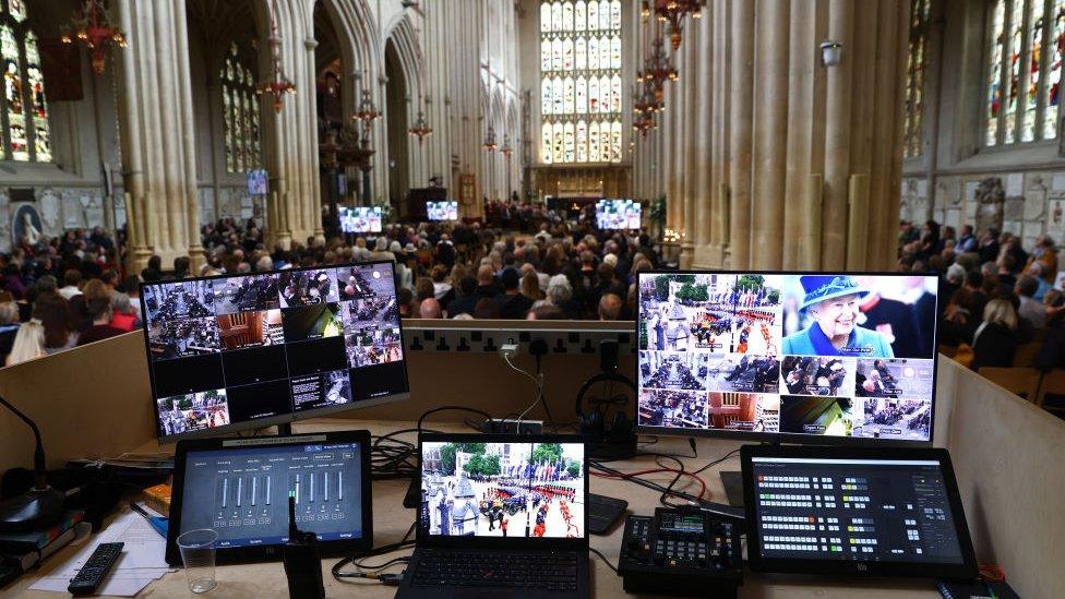 Screens show the broadcasting of the Queen's funeral.