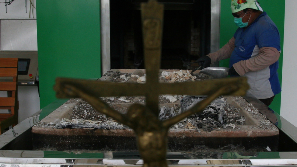 A worker collects ashes after cremation. File photo