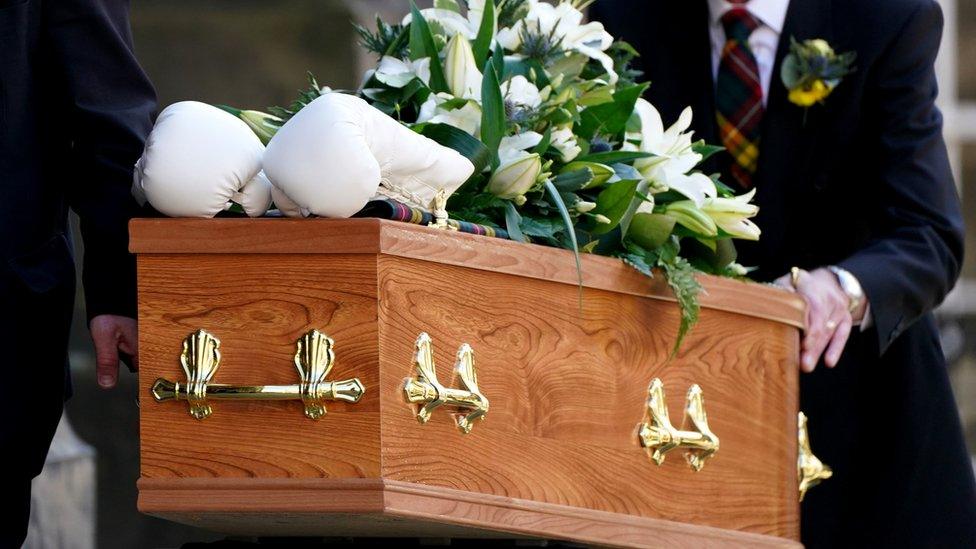 A pair of boxing gloves was placed on the coffin