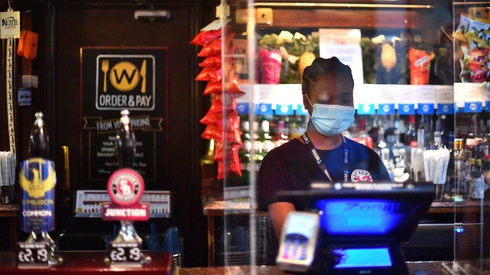 Bar staff waits for customers at the Rochester Castle pub in Stoke Newington, North London