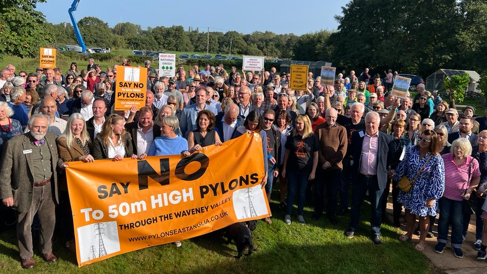 People holding up a banner against pylons