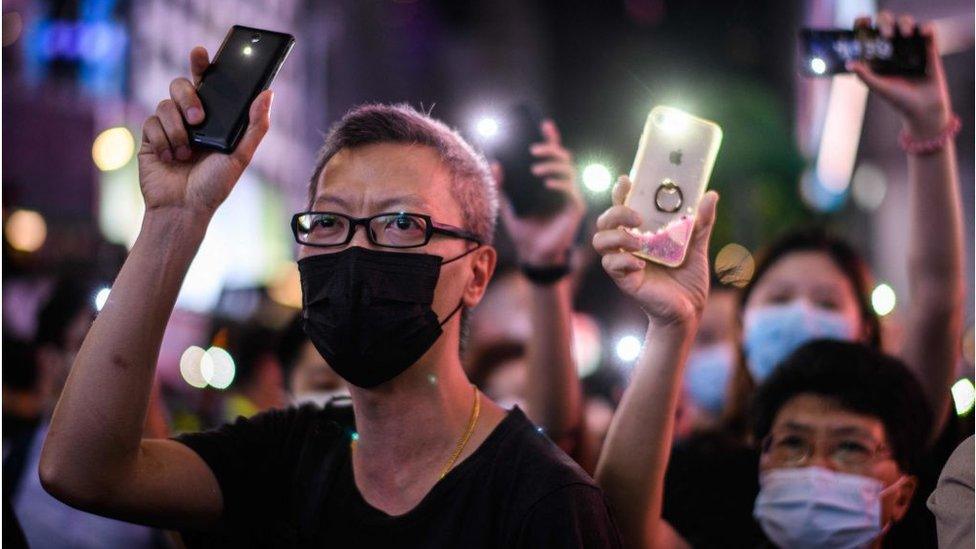 Pro-democracy protesters hold up their mobile phone torches as they sing during a rally in the Causeway Bay district of Hong Kong on June 12, 2020