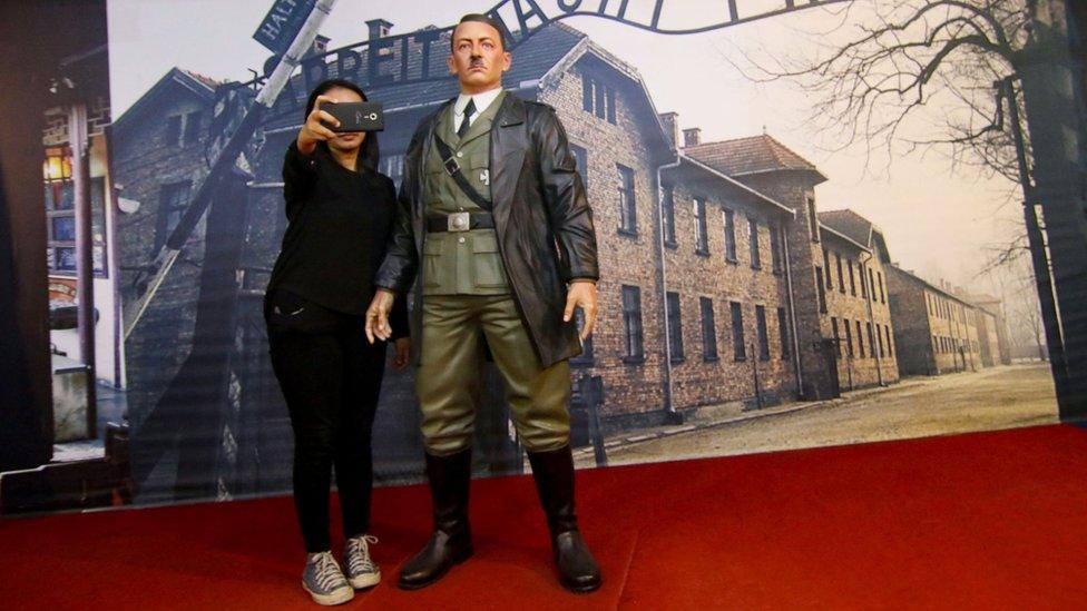 A woman poses with Adolf Hitler waxwork in an Indonesian museum