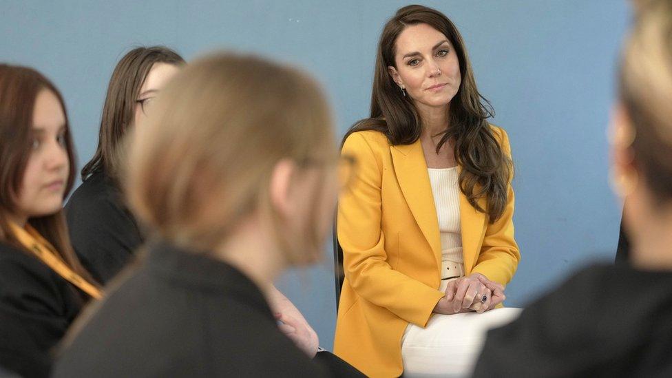 The Princess of Wales wearing a yellow blazer sits in a circle with students