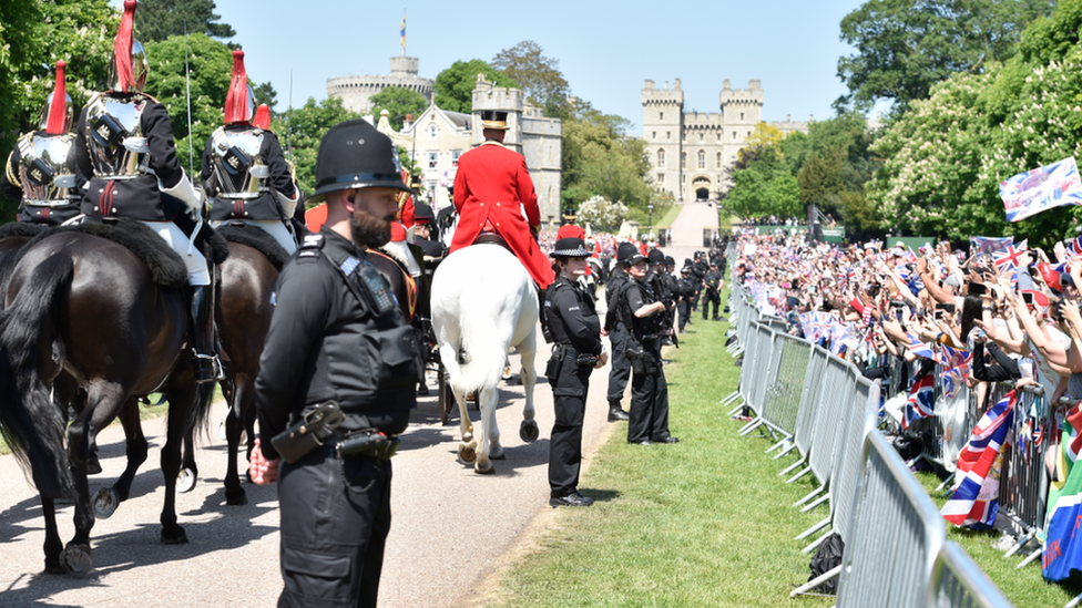 Crowds cheer for Prince Harry, Duke of Sussex, and his wife Meghan, Duchess of Sussex