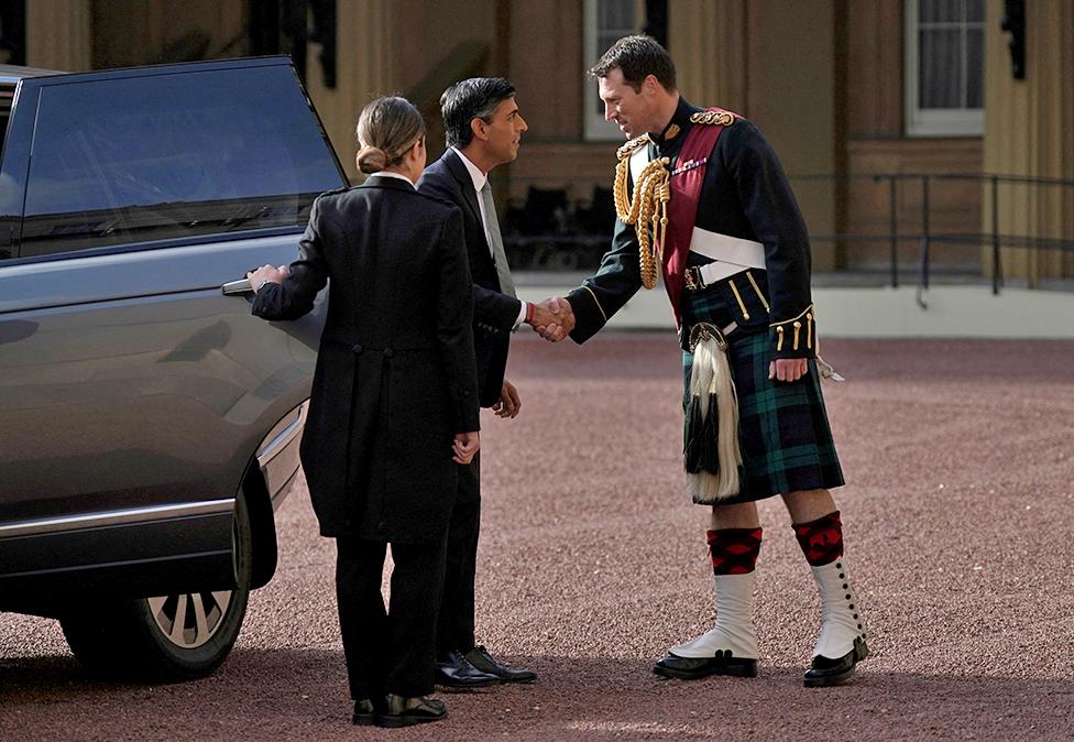 Newly elected leader of the Conservative Party Rishi Sunak, is greeted by King Charles III's equerry, Lieutenant Colonel Johnny Thompson, as he arrives at Buckingham Palace, on 25 October 2022