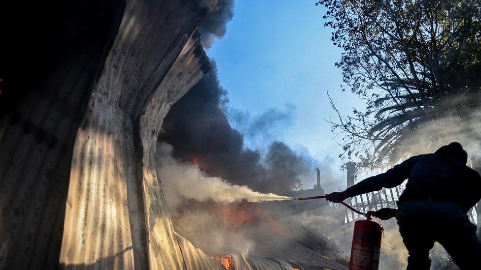 Someone trying to put out a burning shack near Pretoria, South Africa