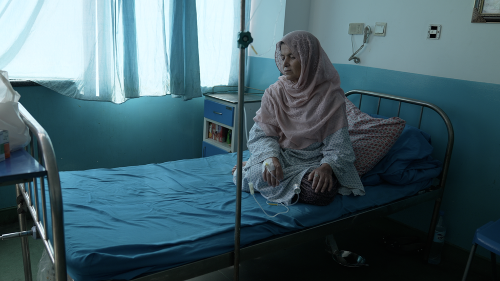 Mazaria sits on a bed in a cancer ward in Kabul