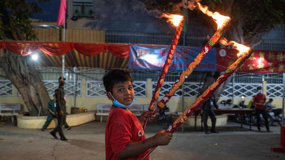 A boy holding candles in Phnom Penh, Cambodia