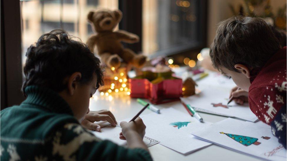 Two young people making Christmas cards