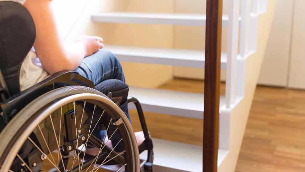 Woman in wheelchair at bottom stairs