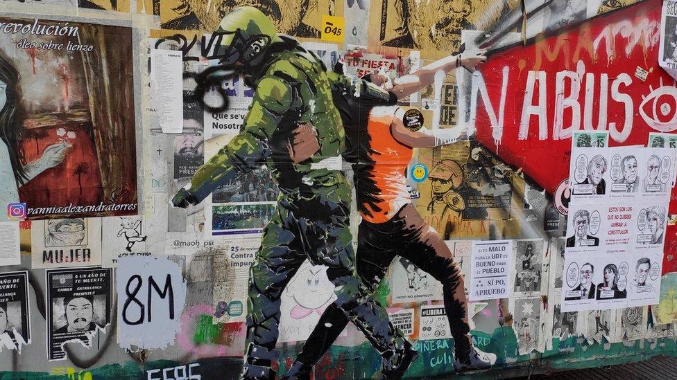 A uniformed man drags a protester by her neck