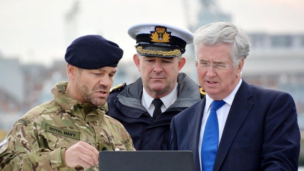 Military personnel show Michael Fallon work to dredge Portsmouth harbour.