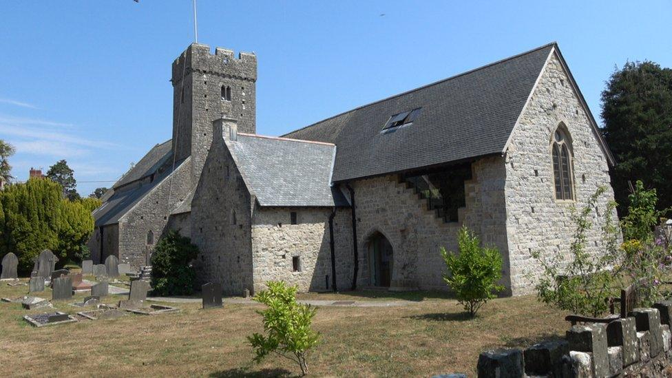 Exterior of St Illtud's Church in Llantwit Major, a 13th Century stone building surrounded by a graveyard