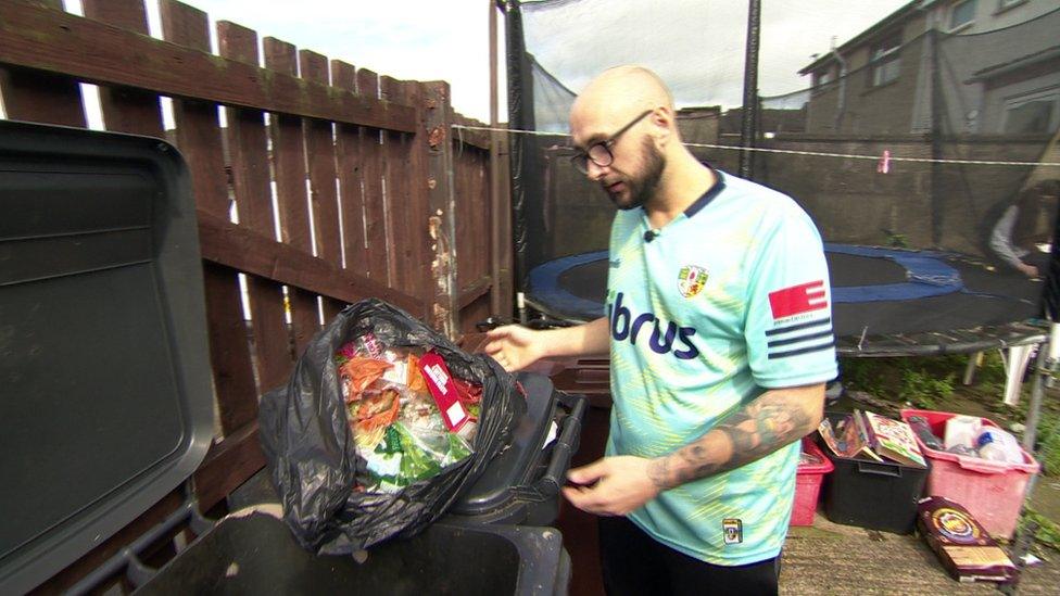 Christopher Stephens shows his bin containing food he had to throw out